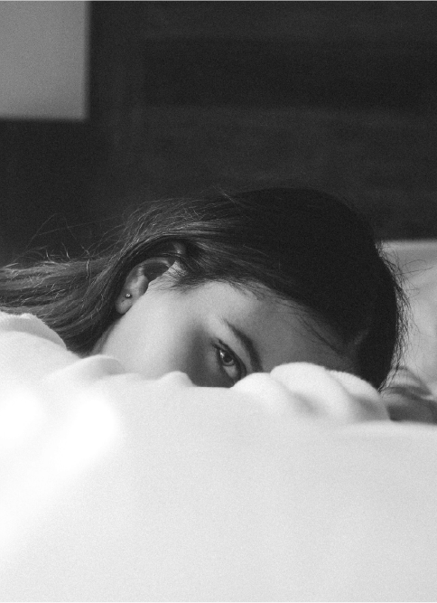 Woman resting head on Bed