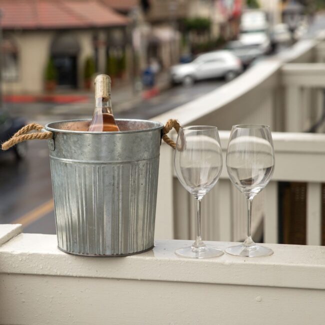 Bottle of wine in ice bucket with two glasses